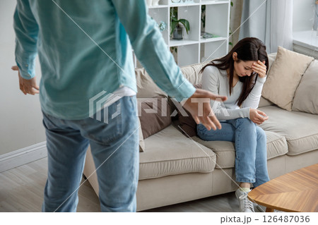 Sad woman sitting on couch after argument with husband, concept of divorce or breakup 126487036
