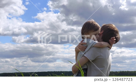 Loving, caring family, happy childhood. Boy in a field in a meadow runs towards brother. family spends time in nature, brothers hug. Brother's Day. little brother runs into the arms of older brother 126487723