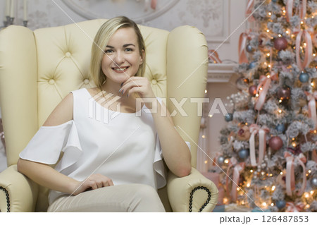 Young ordinary girl on the background of the Christmas tree Young ordinary girl on the background of the Christmas tree 126487853