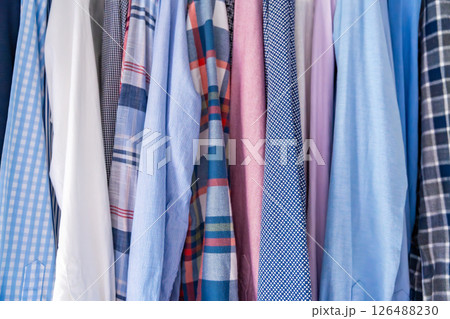Close-up of various men shirts showing different fabrics, textures and colors. Concept of textile variety, material quality and male clothing style. 126488230