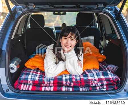 車中泊を楽しむ女性の笑顔と寝袋のアウトドア写真 車中泊を楽しむ女性の笑顔と寝袋のアウトドア写真 126488680