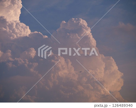 夏の空に湧き上がる入道雲に飛び込む旅客機 126489340
