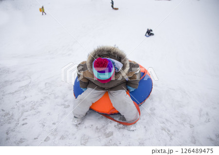 Sledding.Happy child on vacation. Winter fun and games.Little boy enjoying a sleigh ride.Children play outdoors in snow. Kids sled in the Alps mountains in winter Sledding.Happy child on vacation. Winter fun and games.Little boy enjoying a sleigh ride.Children play outdoors in snow. Kids sled in the Alps mountains in winter 126489475