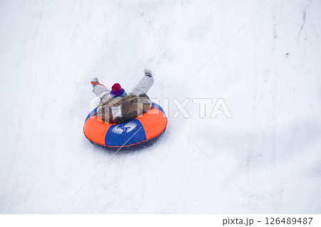 Sledding.Happy child on vacation. Winter fun and games.Little boy enjoying a sleigh ride.Children play outdoors in snow. Kids sled in the Alps mountains in winter 126489487