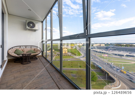 Glazed Balcony with Rattan Lounge and Cityscape Glazed Balcony with Rattan Lounge and Cityscape 126489656