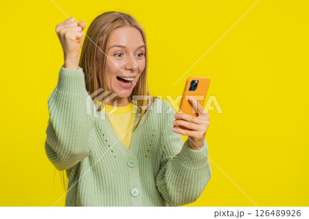 Happy excited winner woman use smartphone celebrating success winning play game good lottery news Happy excited winner woman use smartphone celebrating success winning play game good lottery news 126489926