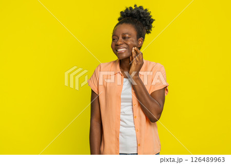 Black woman touching cheek closing eyes with expression of terrible suffer from painful toothache Black woman touching cheek closing eyes with expression of terrible suffer from painful toothache 126489963