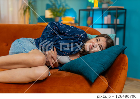 Sick ill Caucasian woman suffering from period cramps, painful stomach ache menstrual pain diarrhea 126490700