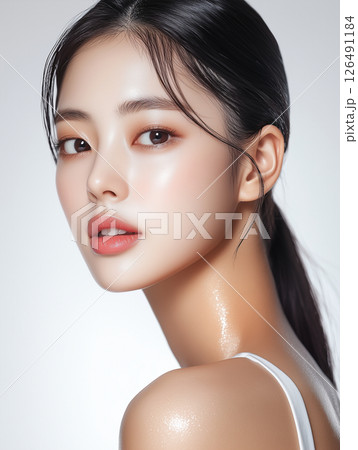 Beautiful Korean woman showcasing radiant skin and natural makeup in a minimalist studio setting 126491184