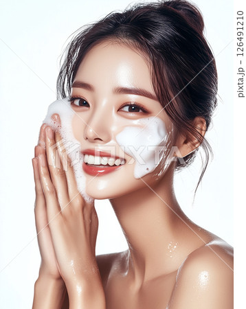 Korean woman enjoying a skincare routine with foam cleanser in a bright, minimalistic setting 126491210