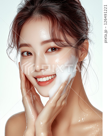 Young Korean woman applying foam skincare product for a fresh and radiant complexion in a bright setting Young Korean woman applying foam skincare product for a fresh and radiant complexion in a bright setting 126491221