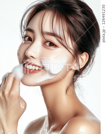 Korean woman enjoying her skincare routine while applying foam cleanser for clear and healthy skin Korean woman enjoying her skincare routine while applying foam cleanser for clear and healthy skin 126491230