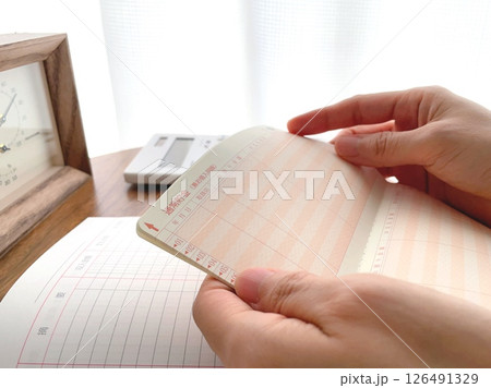 通帳を持つ女性の手元 通帳を持つ女性の手元 126491329