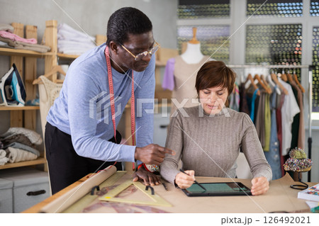 Fashion designers developing new clothing models using table 126492021