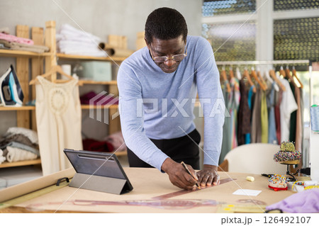 Fashion designer creating clothing patterns in studio 126492107