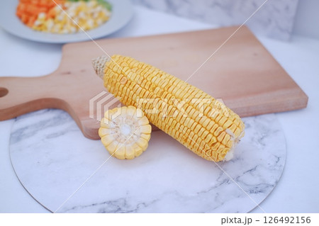 Corn on the cob and corn kernels on a white plate on a white background 126492156