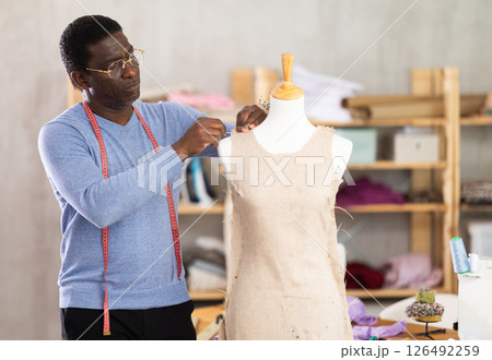 Experienced tailor shaping dress on mannequin in tailoring studio 126492259