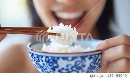 大きな一口でご飯を食べる日本人女性のクローズアップ 126493949