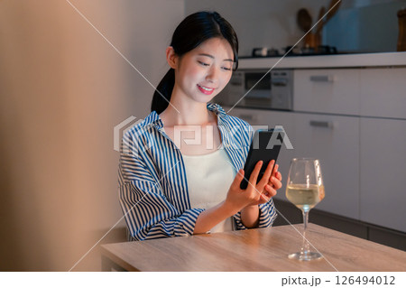 夜に一人で晩酌をする若い女性 夜に一人で晩酌をする若い女性 126494012