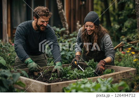 Two smiling gardeners working together in a lush vegetable garden, enjoying their outdoor activity Two smiling gardeners working together in a lush vegetable garden, enjoying their outdoor activity 126494712