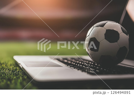 Soccer ball on laptop, sports betting concept in stadium setting 126494891