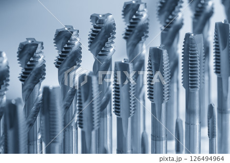 Close up scene the spiral flute threading tap tool for CNC machine in the light blue scene. Close up scene the spiral flute threading tap tool for CNC machine in the light blue scene. 126494964