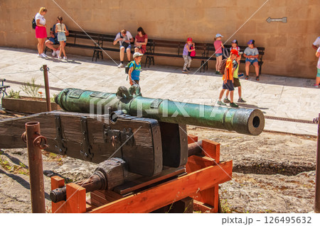 An ancient cannon stands on the pier near the fortress walls of the Bojnice castle. The old cannon is big. 126495632