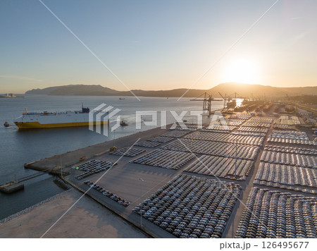 New Cars on Parking Lot and ro-ro Cargo Ship in Port of Setubal. Aerial View New Cars on Parking Lot and ro-ro Cargo Ship in Port of Setubal. Aerial View 126495677