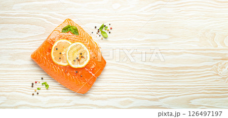 Fresh raw salmon marbled fillet on white rustic wooden table background with lemon, coarse salt, green herbs top view. Healthy cooking and balanced diet 126497197