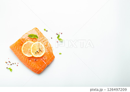 Fresh raw salmon marbled fillet isolated on white background with lemon, coarse salt, green herbs top view. Healthy nutrition and balanced diet. Space for text Fresh raw salmon marbled fillet isolated on white background with lemon, coarse salt, green herbs top view. Healthy nutrition and balanced diet. Space for text 126497209