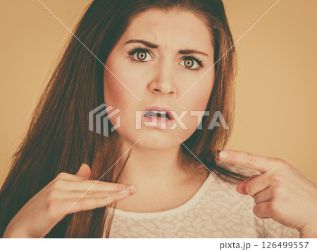 Worried woman looking at her dry hair ends 126499557