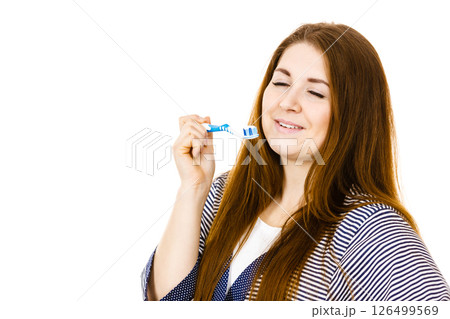 Woman holds toothbrush with paste. Woman holds toothbrush with paste. 126499569