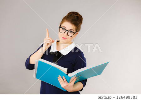 Happy positive business woman holding binder with documents 126499583