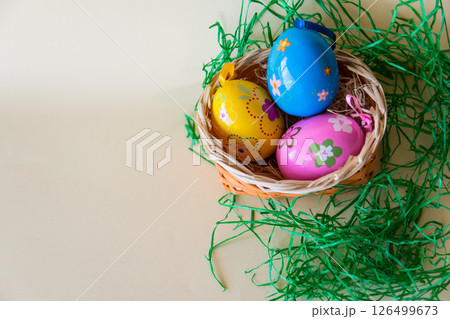 Easter color eggs in nature wicker basket on pastel background. Flat lay. Top view with copy space. Easter concept. Easter color eggs in nature wicker basket on pastel background. Flat lay. Top view with copy space. Easter concept. 126499673