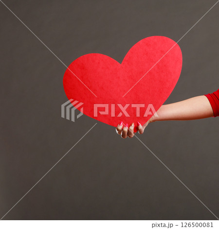 Girl holding big red heart in hands Girl holding big red heart in hands 126500081