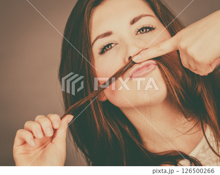 Woman having fun with her hair making moustache 126500266