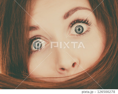 Woman having face covered with her brown hair 126500278