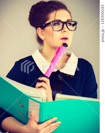 woman thinking holds file folder with documents 126500285