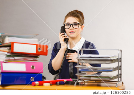 Business woman in office talking on phone Business woman in office talking on phone 126500286