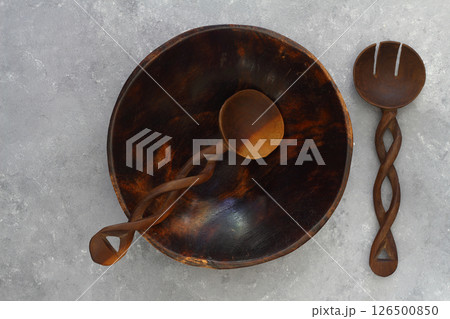 Empty round handcrafted brown wooden plate on stone concrete background, top view 126500850