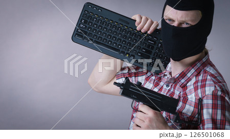 Man in balaclava holding keyboard and gun 126501068