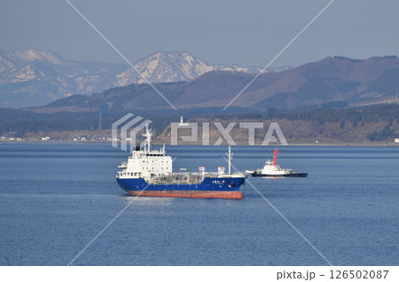 春の北海道函館市で函館湾に停泊中の貨物船とクルーズ船を迎えに行くタグボートの風景を撮影 126502087