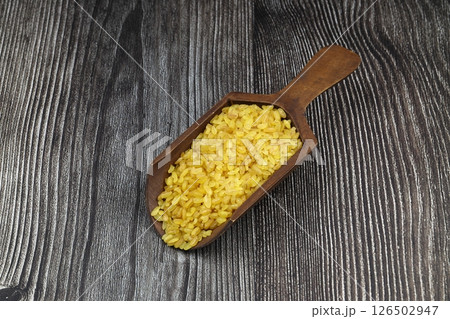 Dry bulgur wheat grains with a spoon close up 126502947
