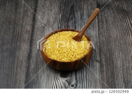 Dry bulgur wheat grains with a spoon close up 126502949