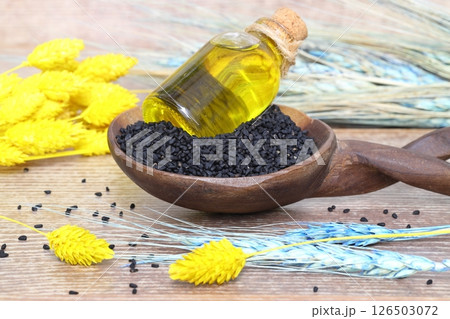 Black cumin seeds and essential oil with bowl and wooden shovel or spoon. Nigella Sativa Black cumin seeds and essential oil with bowl and wooden shovel or spoon. Nigella Sativa 126503072