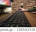 Black keyboard resting on wooden desk near computer mouse, programmer working intently at home office workspace 126503316