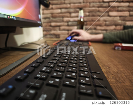 Black keyboard resting on wooden desk near computer mouse, programmer working intently at home office workspace 126503316