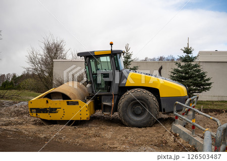 Yellow road roller parked on construction site 126503487