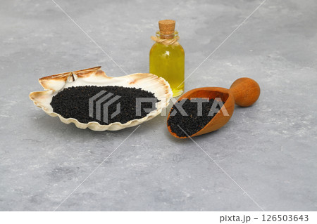 Black cumin seeds and essential oil with bowl and wooden shovel or spoon. Nigella Sativa Black cumin seeds and essential oil with bowl and wooden shovel or spoon. Nigella Sativa 126503643