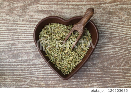 Dry organic background or texture of rosemary leaves. Healthy food concept . a wooden spoon with rosemary 126503686
